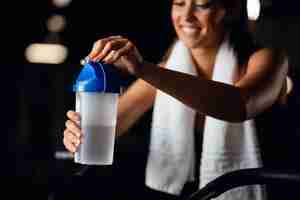 Free photo close up of thirsty sportswoman opening plastic cup while exercising in fitness center