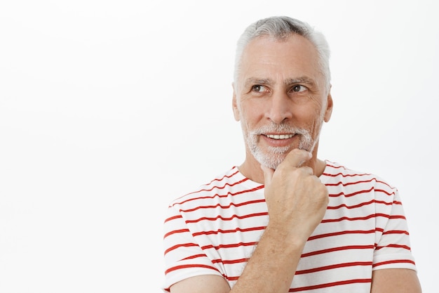 Free photo close-up of thoughtful handsome senior man looking pleased upper left corner