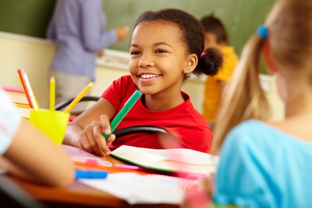 Close-up of thoughtful little girl holding a highlighter