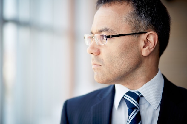 Close-up of thoughtful worker with glasses