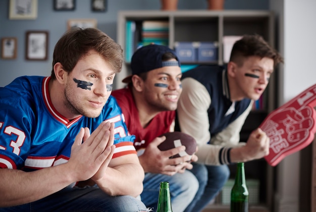 Close up of three fans wearing sports clothes