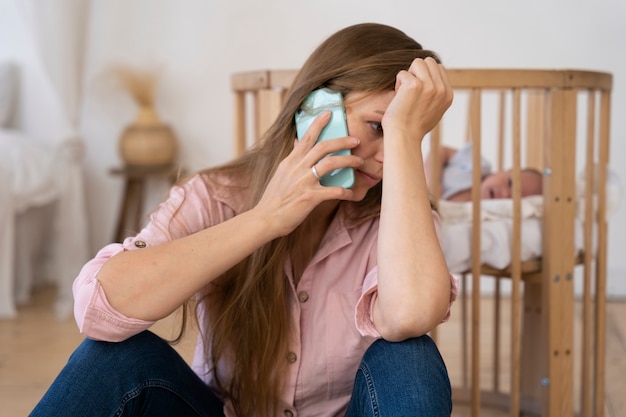 Close up on tired mom taking care of newborn baby