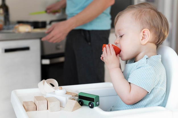 Free photo close up toddler eating tomato