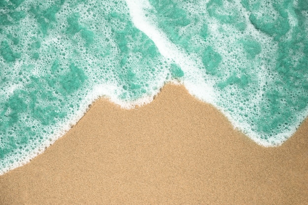 Close-up top view of bubbly water on tropical sandy beach