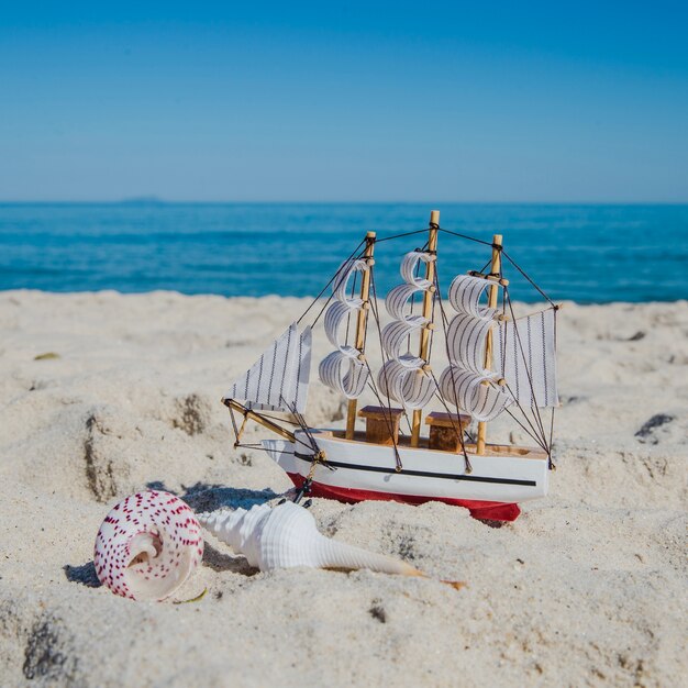 Крупный план игрушечного корабля на песке