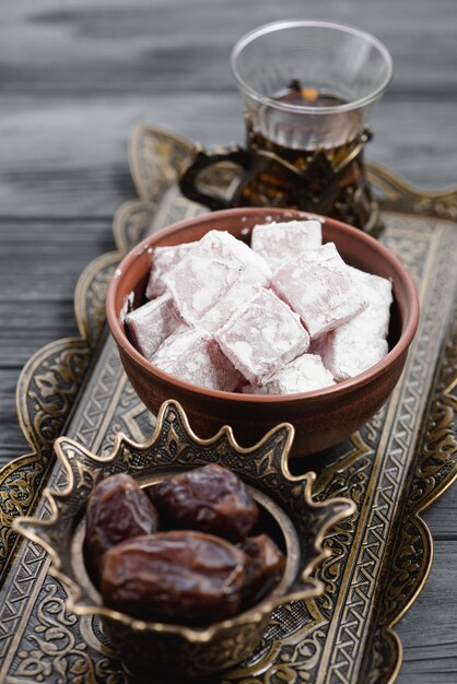 전통적인 터키어 기쁨 lukum의 근접; 금속 쟁반에 날짜와 차