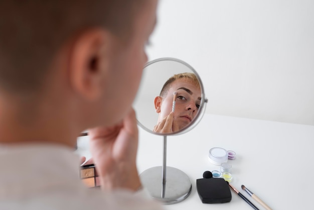 Бесплатное фото Крупным планом трансгендер смотрит в зеркало
