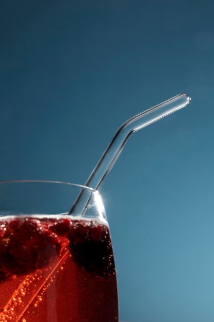 Close-up of transparent beverage glass with glass straw
