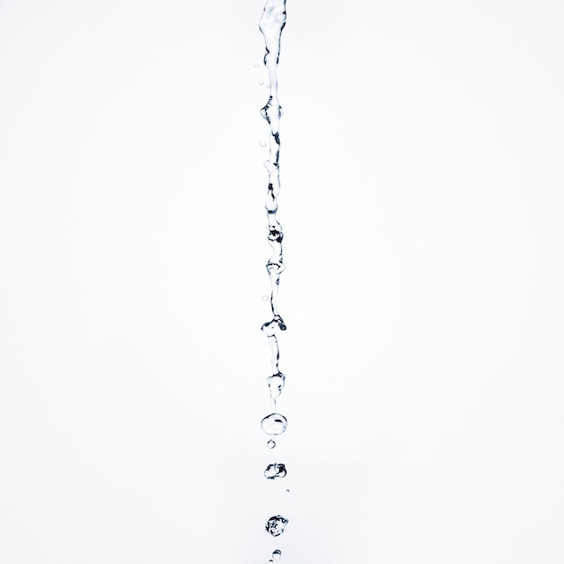 Close-up transparent liquid flowing on white background