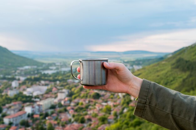 Close-up traveler holding thermos cup