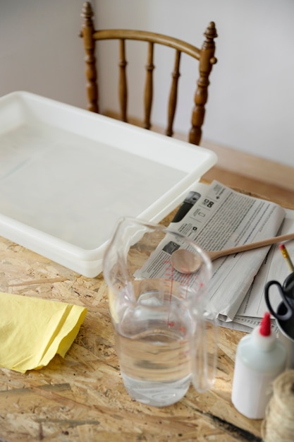 Close-up of a tray and jar filled with water on desk