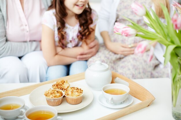 カップケーキと紅茶のカップとトレイのクローズアップ