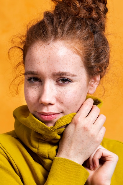 Close-up trendy woman posing with yellow hoodie