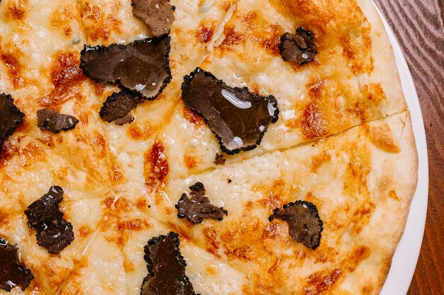 Close up of truffle pizza garnished with olive oil