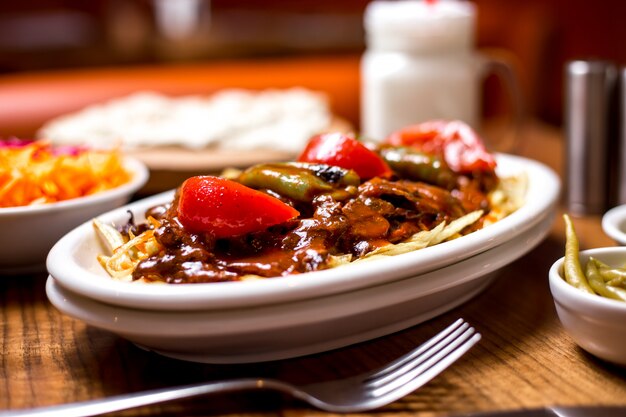 Close up of turkish beef kebab garnished with spicy tomato sauce