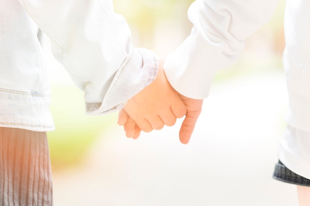 Close-up of two children holding hands