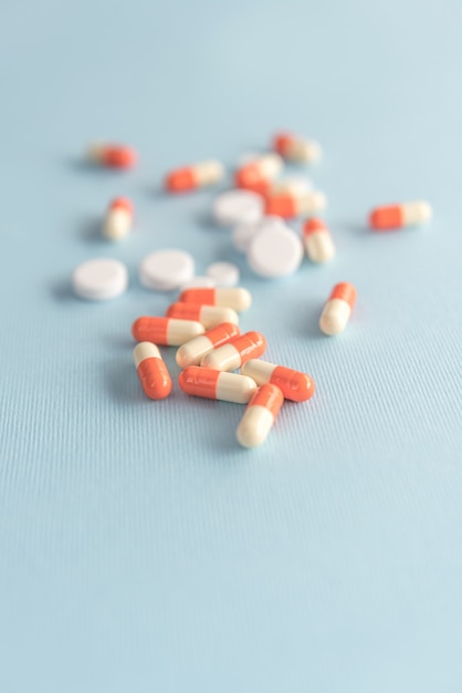 Close up of two colored capsules and white pills