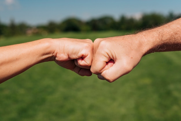 Close-up two fists hitting outdoors