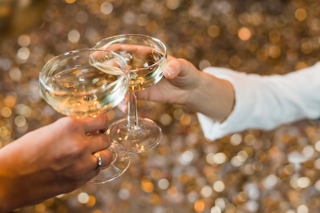 Close-up of two hands toasting whiskey