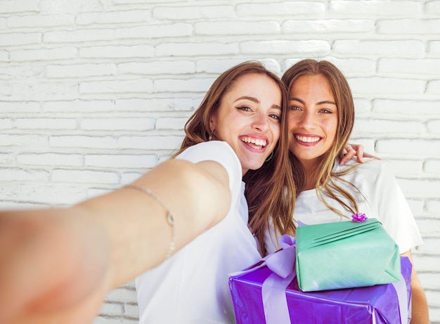 Free photo close-up of two happy female friends with birthday gifts