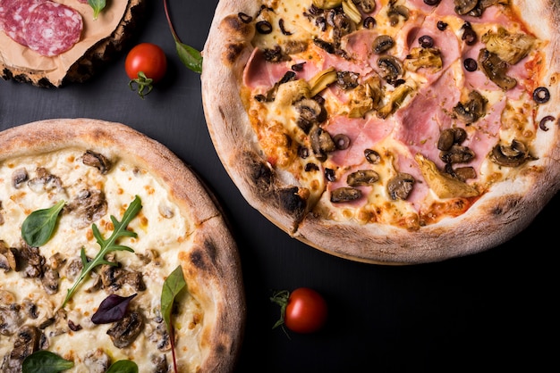 Close-up of two italian pizza with different toppings and cherry tomato