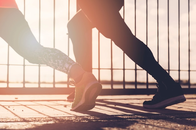 Close-up of two people stretching outdoors