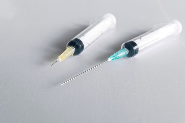Close-up of two syringes on white backdrop