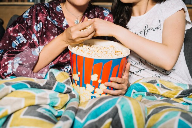 Close-up of a two women sharing popcorn