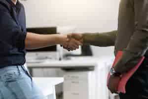 Free photo close up of two young colleagues shaking hands