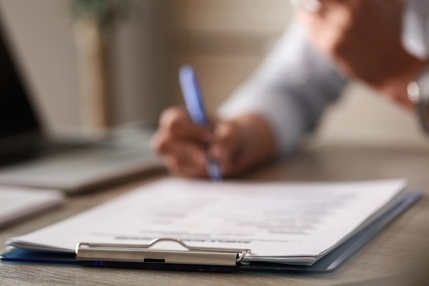 Close up of unrecognizable business person signing documents in the office