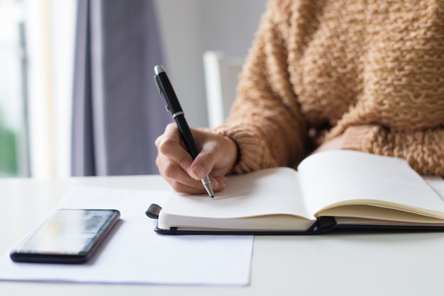 Free photo close-up of unrecognizable lady making notes