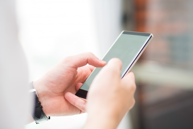 Close-up of unrecognizable man touching smartphone screen