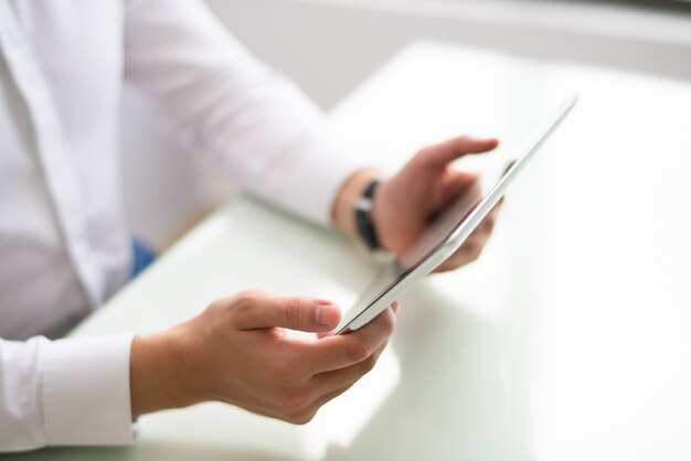 Close-up of unrecognizable man watching video on tablet