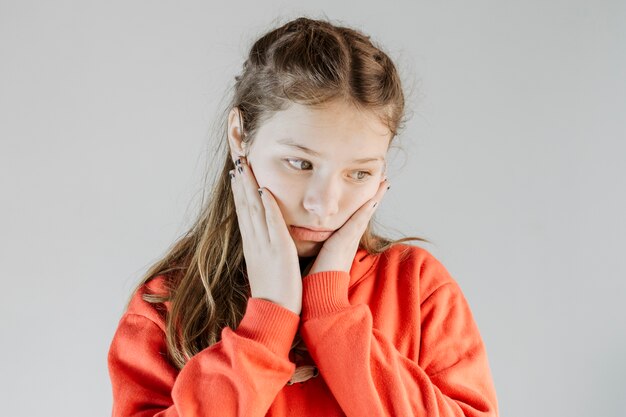 Close-up of an upset girl on grey background