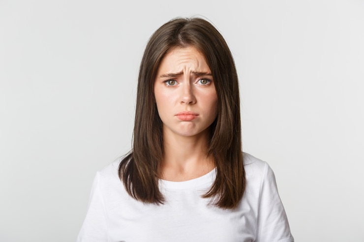 Free Photo close-up of upset and gloomy cute brunette girl sulking, looking miserable.