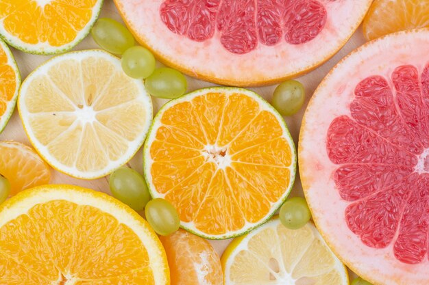 Close up various citrus fruit slices and grapes. 