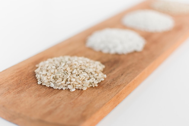Free photo close-up of various uncooked rice on wooden tray