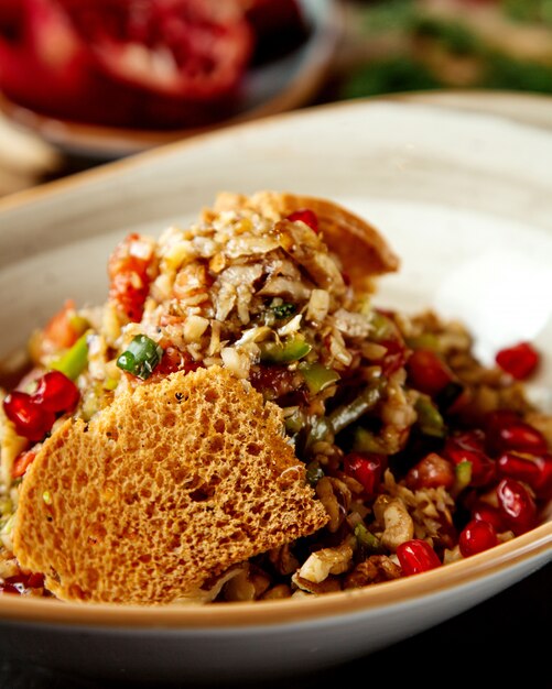 Close up of vegetable salad with walnut pomegranate and bread toast