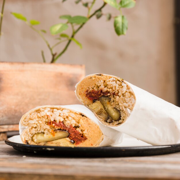 Close-up of vegetarian burrito wrap on plate over the table