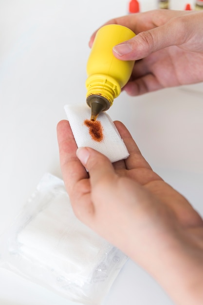 Close-up of veterinarian pouring chemical on medical gauze