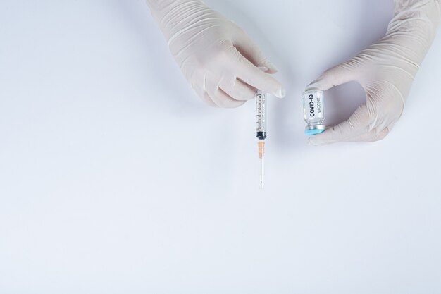 Close up a vial of covid-19 vaccine in hand of a scientist or doctor