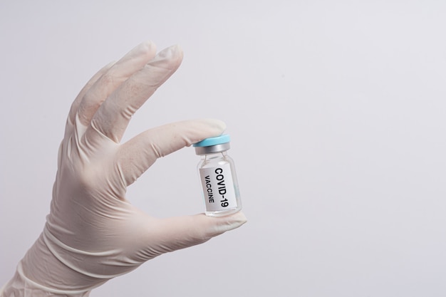 과학자 또는 의사의 손에 코로나 19 백신 바이알을 닫습니다.