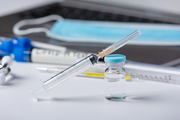 Close up a vial of covid-19 vaccine in hand of a scientist or doctor