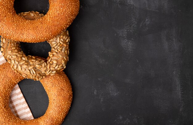 Close-up view of bagels on left side and black background with copy space