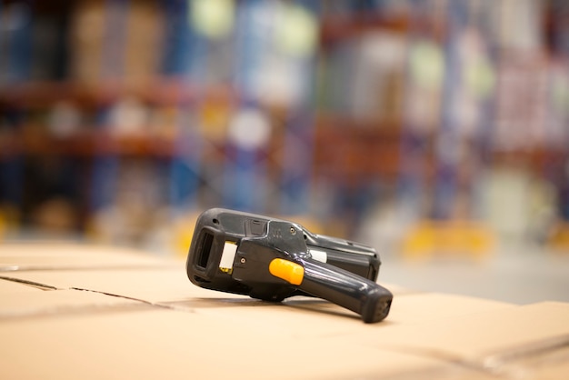 Close up view of bar code scanner placed on cardboard boxes in large distribution warehouse facility