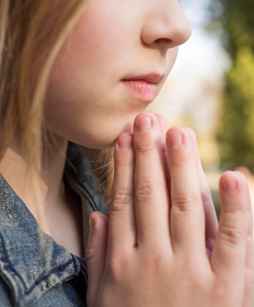 Close-up view of beautiful blonde girl praying