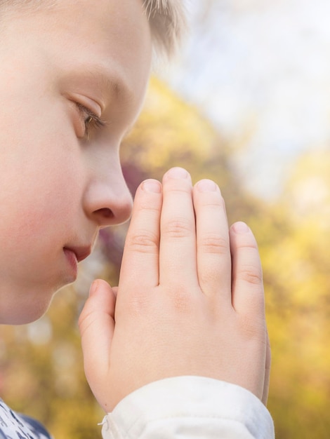 Free photo close-up view of beautiful little boy praying