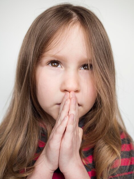 Close-up view of beautiful little girl praying