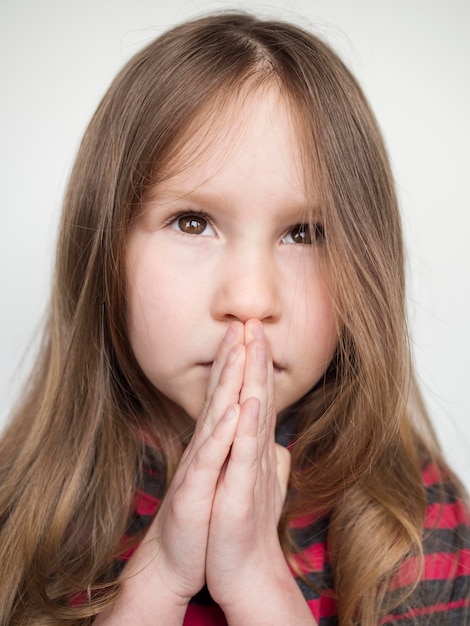 Close-up view of beautiful little girl praying