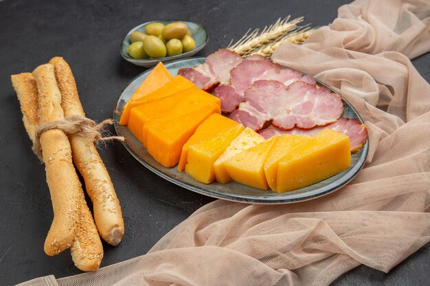 Close up view of best delicious snacks for wine on a towel on a dark table